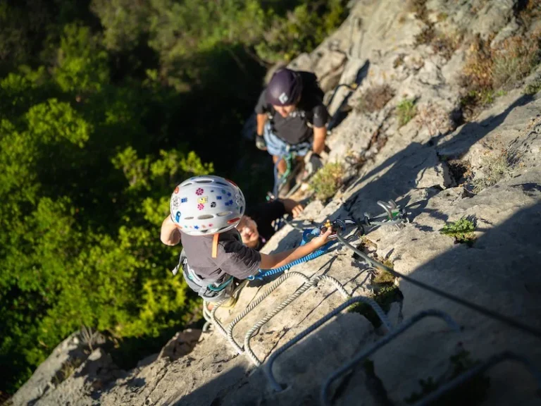Enfant équipé progressant sur une paroi rocheuse lors d’une sortie Via Ferrata famille à Saint-Paul-de-Fenouillet.