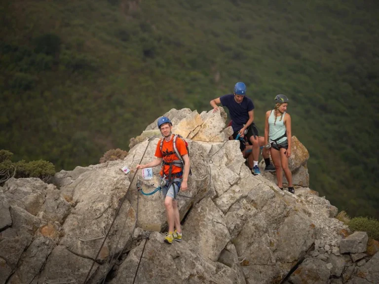 Participants faisant une pause sur une arête rocheuse lors de la Via Ferrata La Panoramique à Saint-Paul-de-Fenouillet.