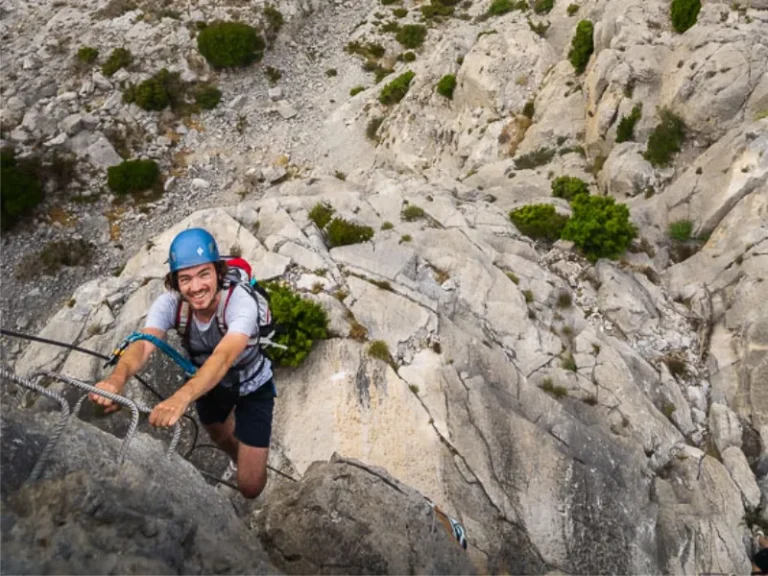 Participant grimpant sur une section verticale de la Via Ferrata La Panoramique à Saint-Paul-de-Fenouillet.