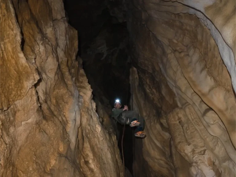 Spéléologue descendant dans un puits de grotte lors d’une sortie spéléologie dans les Pyrénées-Orientales
