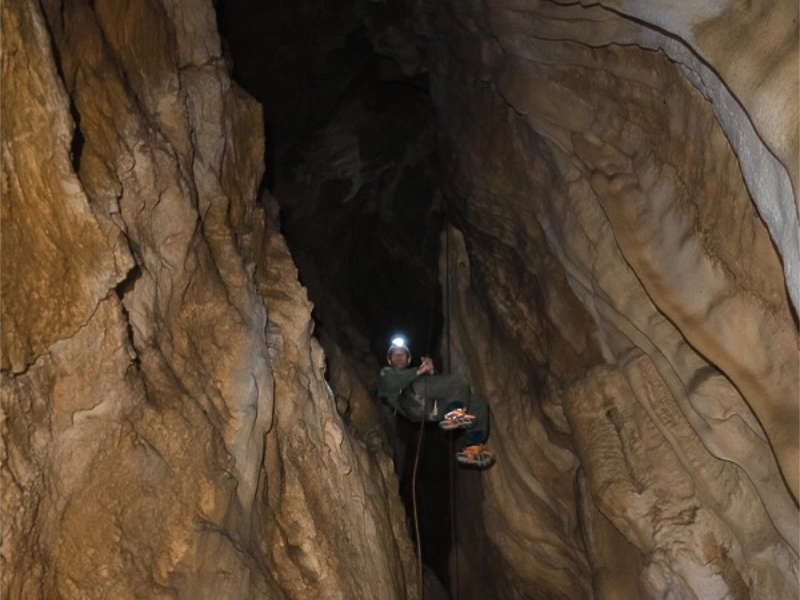 Spéléologue descendant dans un puits de grotte lors d’une sortie spéléologie dans les Pyrénées-Orientales