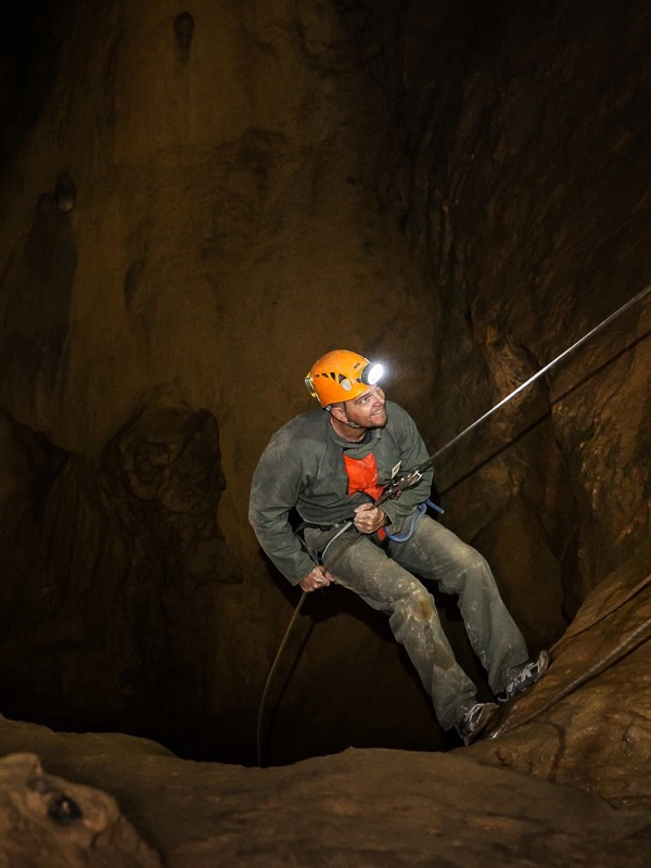 Spéléologue descendant en rappel dans une grotte lors d’une sortie spéléologie dans les Pyrénées-Orientales
