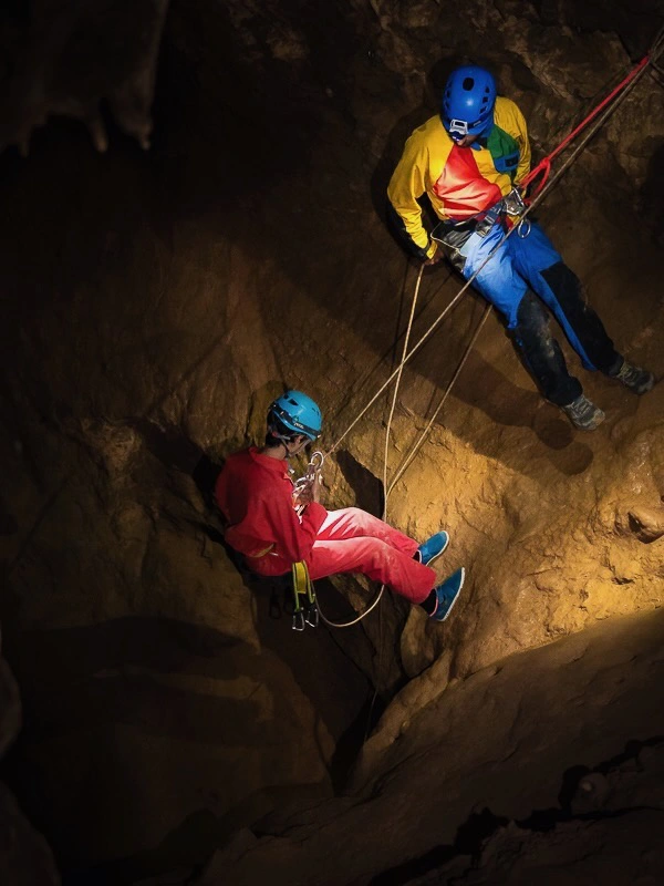 Participants descendant en rappel dans une grotte lors d’une sortie spéléologie dans l’Aude près de Galamus