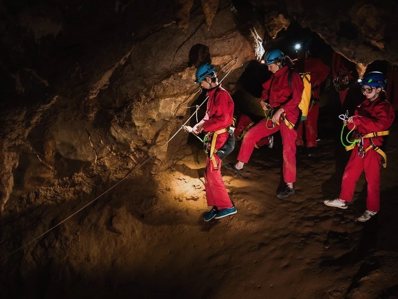 Famille explorant une grotte lors d’une sortie spéléologie près de Saint-Paul-de-Fenouillet dans les Pyrénées-Orientales