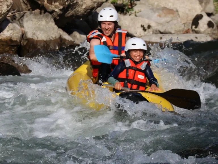 parent et enfant en canoraft franchissant un rapide sur la rivière Aude près d’Axat dans les Pyrénées audoises