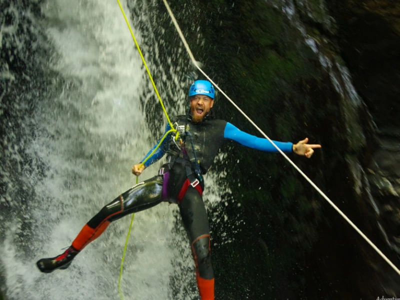 Descente en rappel sous une cascade dans le canyon de Marc en Ariège lors d’une sortie canyoning dans la vallée de Vicdessos