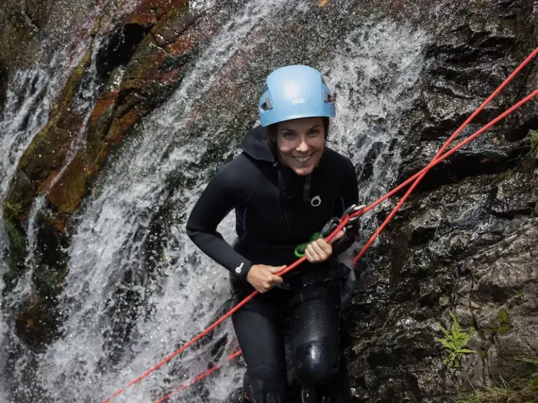 Pratiquante en descente en rappel dans une cascade du canyon du Baousous à Céret dans les Pyrénées-Orientales