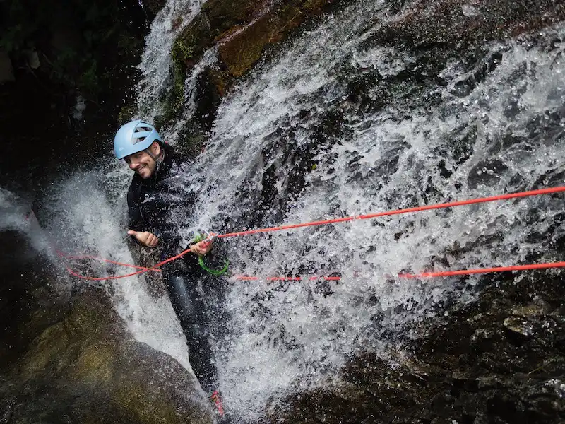 participant descendant une cascade en canyoning dans le canyon des Baoussous près de Céret