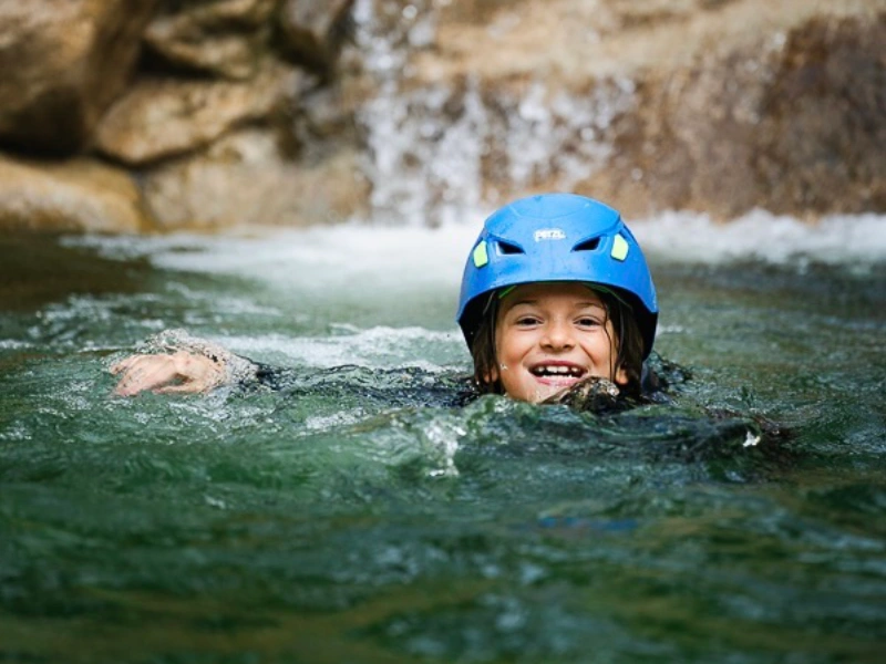 Enfant nageant dans une vasque lors d’une sortie canyoning famille dans les gorges de Galamus près de Saint-Paul-de-Fenouillet