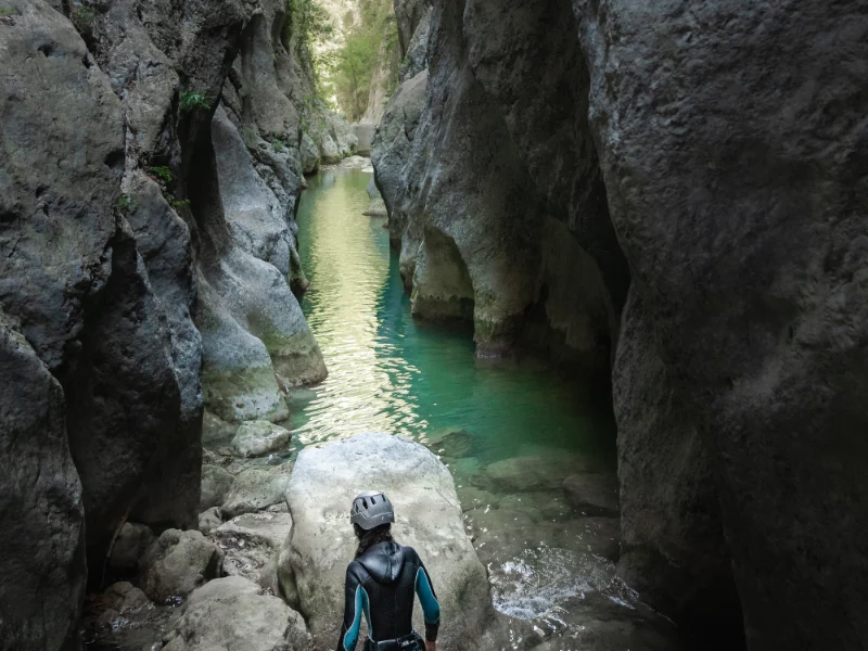 Participant observant une vasque dans les gorges de Galamus lors d’une sortie canyoning dans les Pyrénées-Orientales