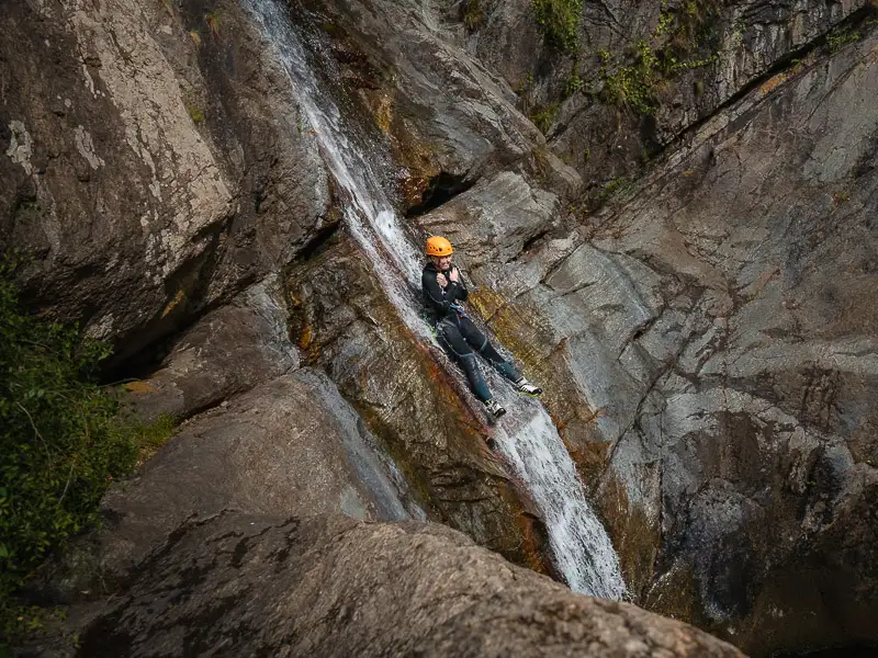 Participant descendant un toboggan naturel dans une cascade du canyon des Anelles à Céret dans les Pyrénées-Orientales