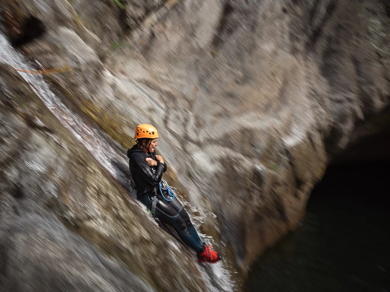 Participant descendant un toboggan naturel dans le canyon des Anelles à Céret dans les Pyrénées-Orientales lors d’une sortie canyoning