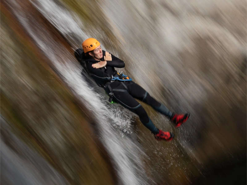 Participant descendant rapidement un toboggan naturel dans le canyon des Anelles à Céret dans les Pyrénées-Orientales
