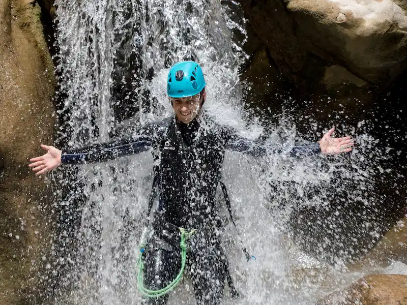 Participant sous une cascade lors d’une sortie canyoning dans les Gorges du Terminet à Termes dans l’Aude