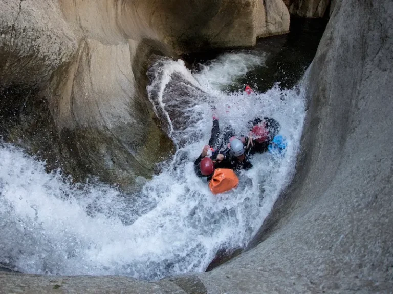 roupe de participants descendant un toboggan naturel dans le canyon du Llech lors d’une sortie de canyoning dans les Pyrénées-Orientales près de Prades