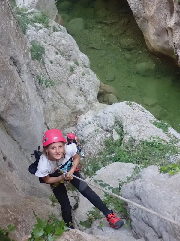 Jeune participante descendant en rappel dans le canyon de l’Ermitage au-dessus de la rivière des gorges de Galamus près de Saint-Paul-de-Fenouillet