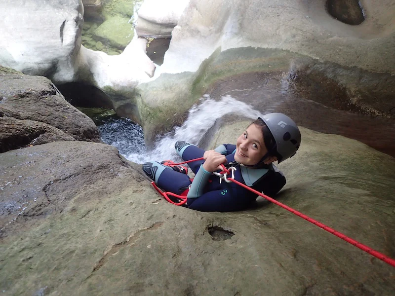 Jeune participante descendant en rappel dans une cascade lors d’une sortie canyoning dans les Gorges du Terminet à Termes dans l’Aude