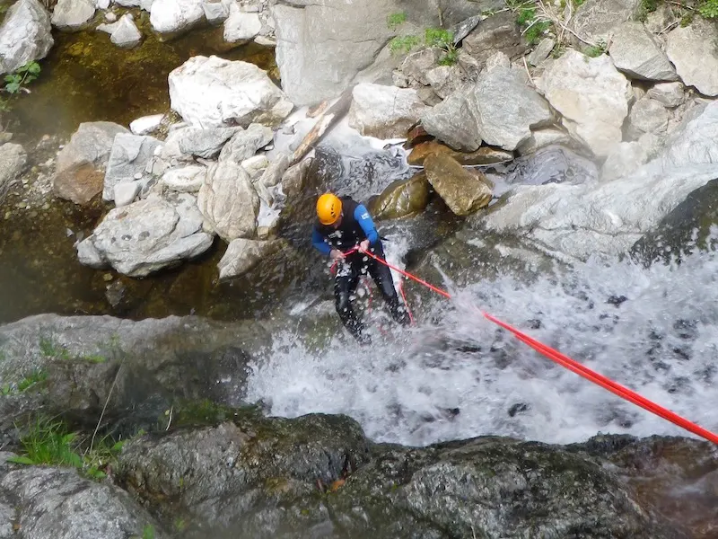 Participant réalisant une descente en rappel dans une cascade du canyon du Mas Calsan lors d’une sortie canyoning près de Céret dans les Pyrénées-Orientales.