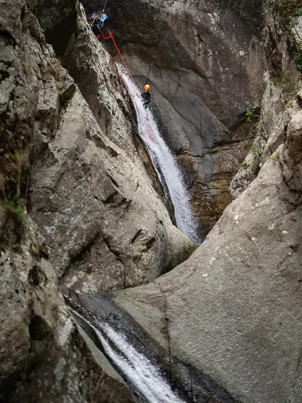 Participant descendant une cascade en rappel dans le canyon du Llech lors d’une sortie de canyoning dans les Pyrénées-Orientales