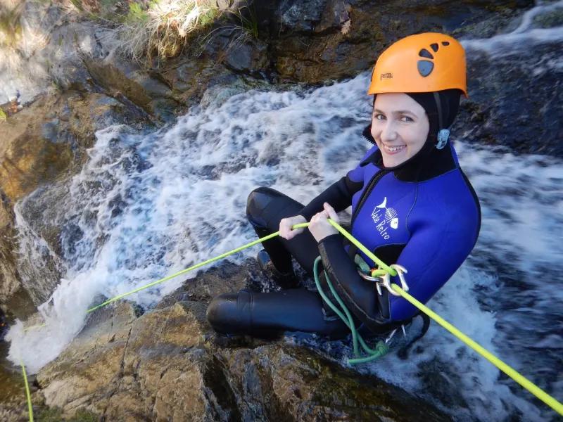 Pratiquante en descente en rappel dans une cascade du canyon d’eau chaude de Thuès lors d’une sortie canyoning hivernale dans les Pyrénées près de Font-Romeu