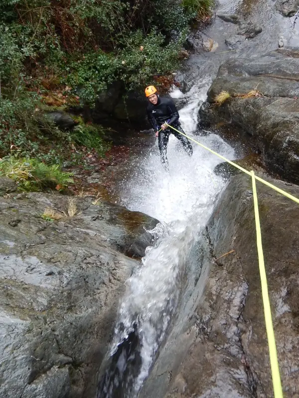 Pratiquant descendant en rappel dans une cascade du canyon d’eau chaude de Thuès lors d’une sortie canyoning hivernale dans les Pyrénées-Orientales près de Font-Romeu