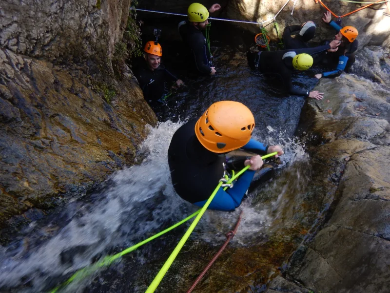 Participant descendant en rappel dans une cascade lors d’une sortie canyoning hivernale dans le canyon d’eau chaude de Thuès près de Font-Romeu