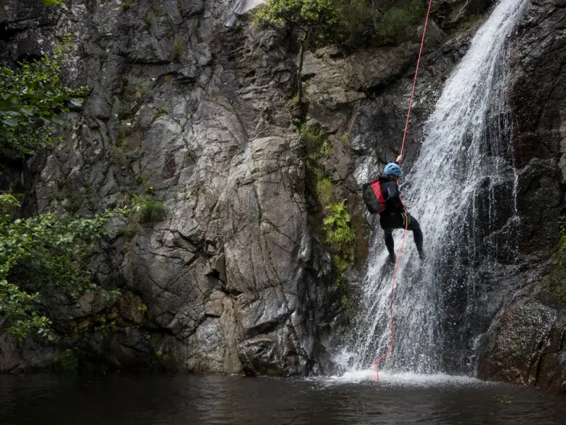 Pratiquant descendant en rappel le long d’une cascade dans le canyon du Baousous à Céret dans les Pyrénées-Orientales