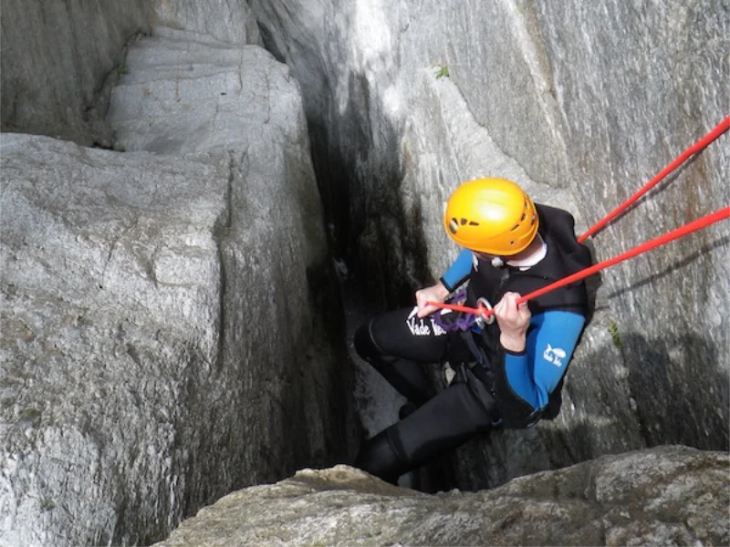 Participant réalisant le célèbre rappel dans la faille étroite du canyon du Mas Calsan lors d’une sortie canyoning près de Céret dans les Pyrénées-Orientales.