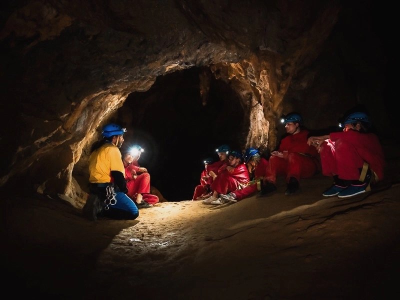 groupe découvrant la spéléologie dans une grotte des Pyrénées-Orientales avec un guide