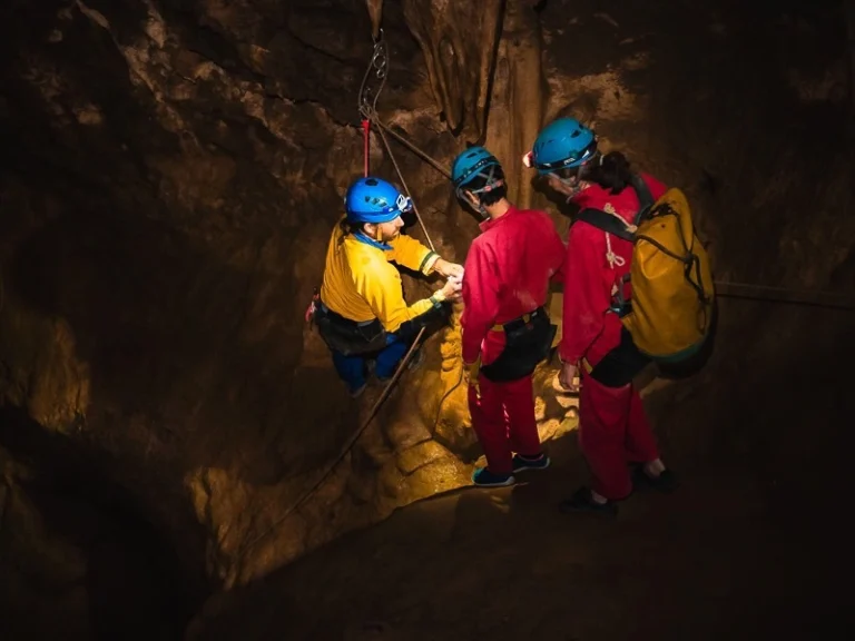 guide expliquant une technique de corde lors d’une sortie spéléologie dans une grotte des Pyrénées-Orientales