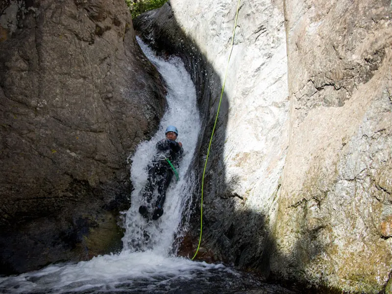 Participant en canyoning descendant un toboggan naturel dans le canyon des Anelles à Céret dans les Pyrénées-Orientales