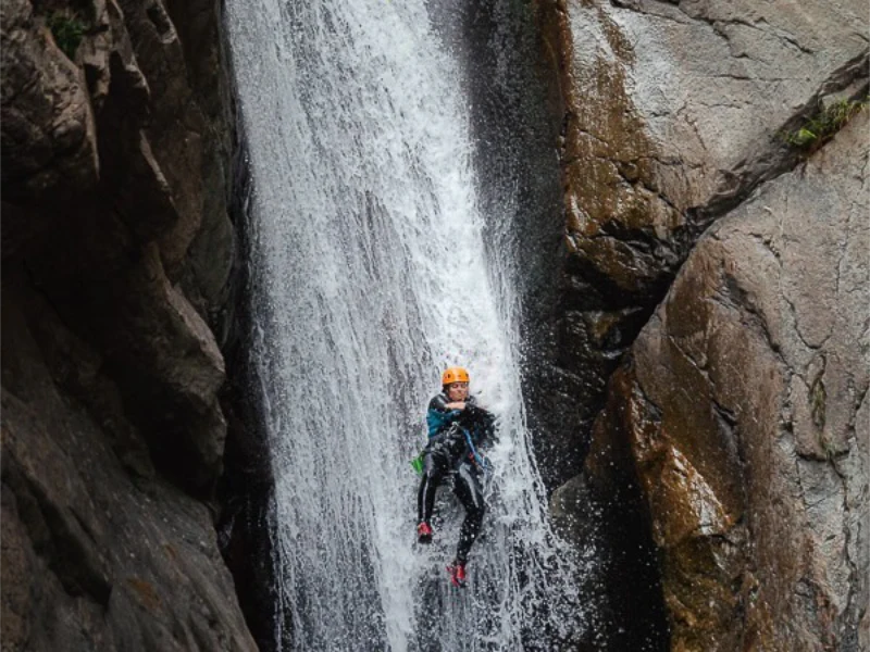 Participant descendant un toboggan vertical dans le canyon du Llech lors d’une sortie de canyoning dans les Pyrénées-Orientales près de Prades