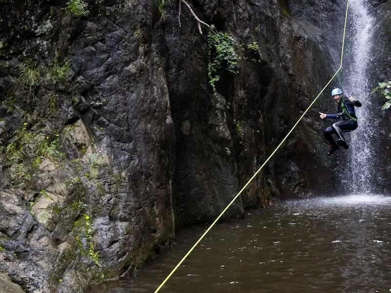 Pratiquant descendant une tyrolienne au-dessus d’une vasque dans le canyon du Baousous à Céret dans les Pyrénées-Orientales