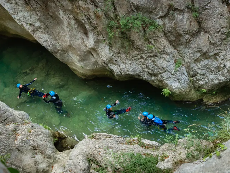 Groupe de participants en canyoning dans une vasque des gorges de Galamus