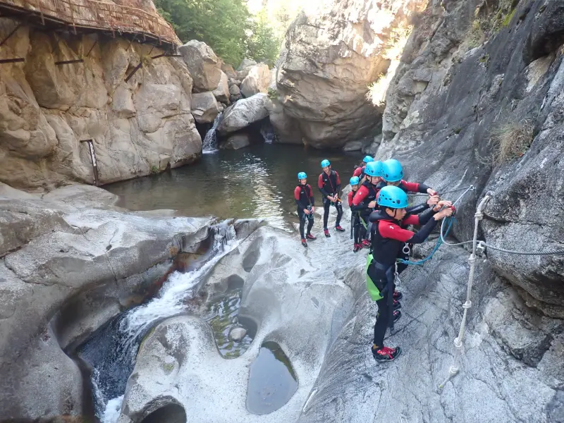 Groupe de participants en progression dans le canyon de Molitg-les-Bains au cœur des gorges de la Castellane dans les Pyrénées-Orientales